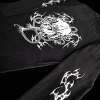 Side view of black long sleeve shirt with white manga-style rope-bound character and neo-tribal print